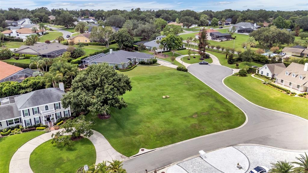 An aerial view shows a large, grassy residential lot surrounded by houses and a cul-de-sac — PIER PLACE DRIVE, LAKELAND, FL