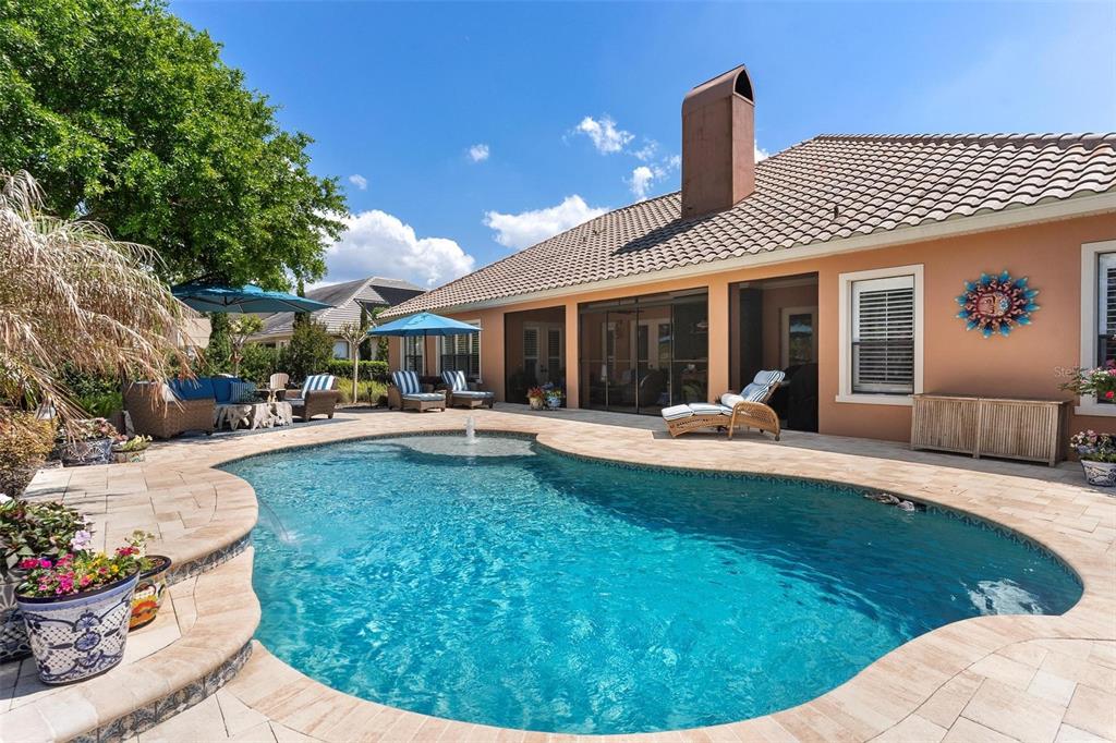 A backyard features a swimming pool with a fountain and a covered patio area — 3001 ISOLA BELLA BOULEVARD, MOUNT DORA, FL