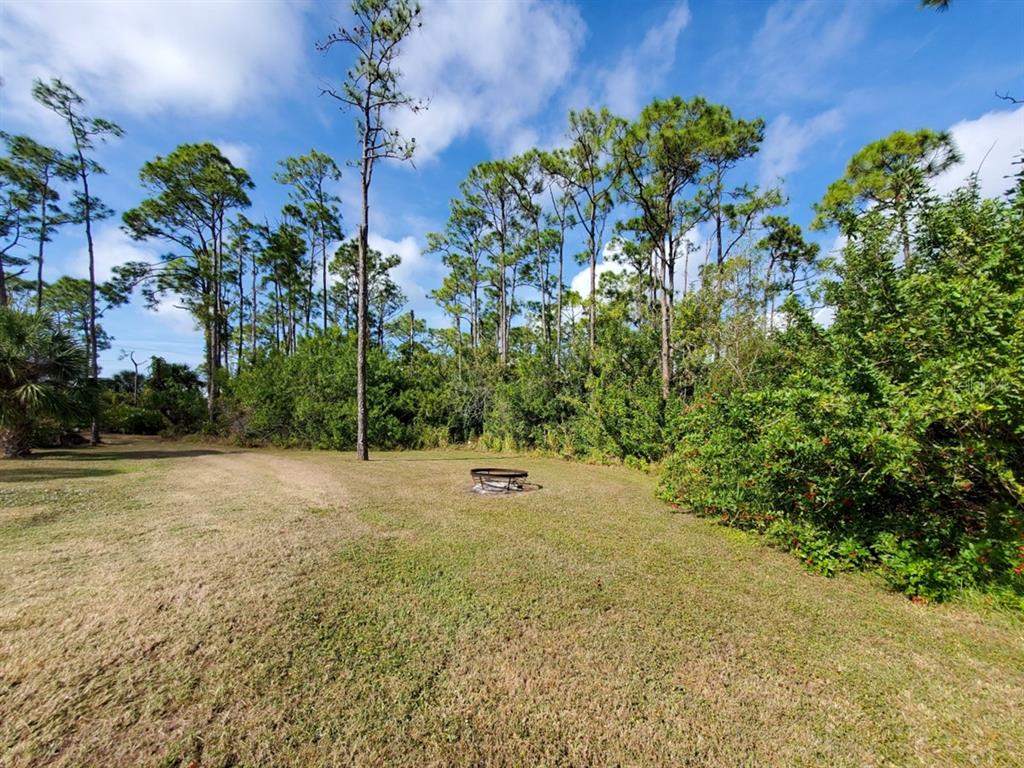 A white house with a metal roof, a screened-in patio, and a detached carport — 18 RIVERFRONT DRIVE, VENICE, FL