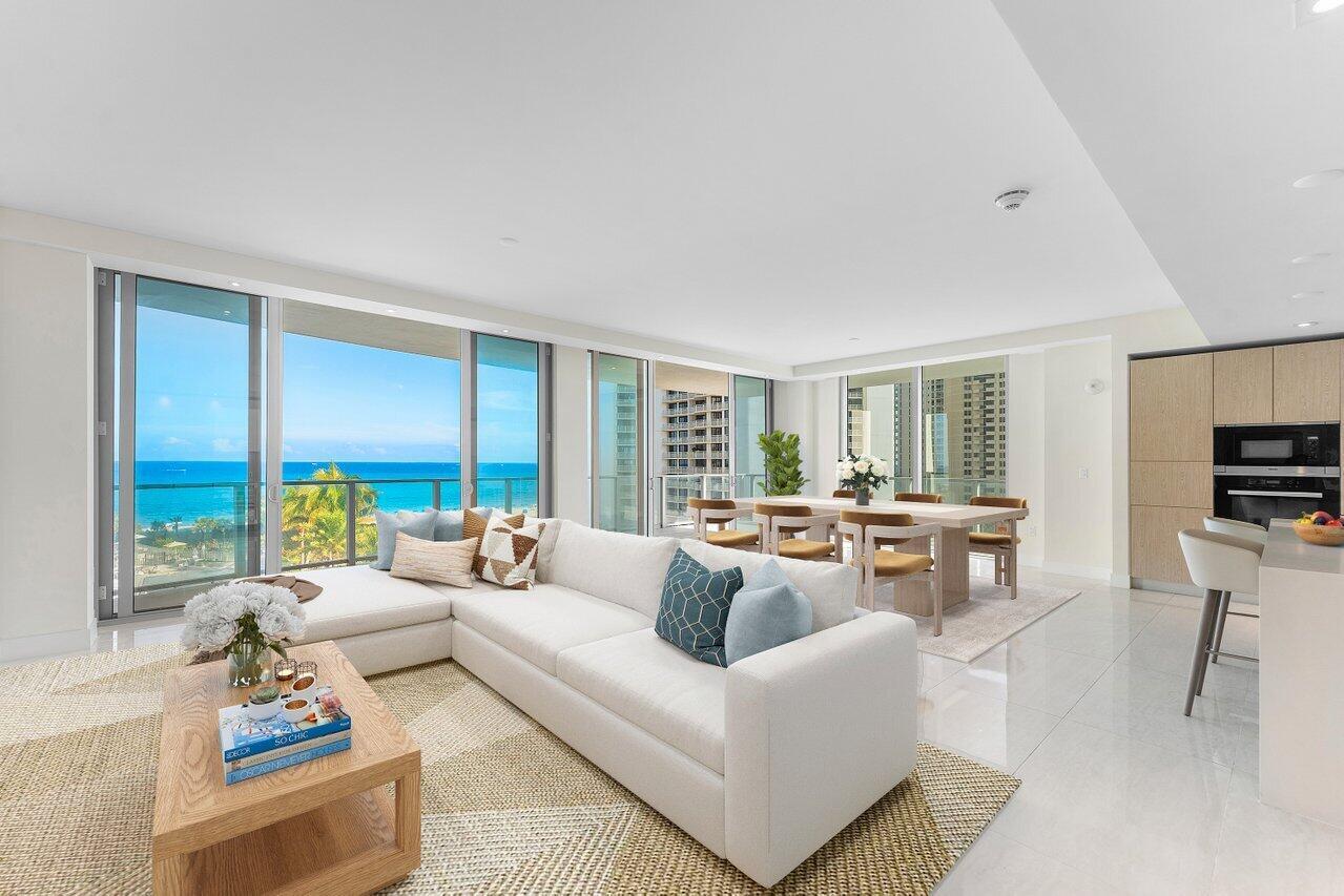 A modern living room with a white sectional sofa, dining area, and ocean view balcony — 3100 N Ocean Drive # P705, Riviera Beach FL 33404, RIVIERA BEACH, FL