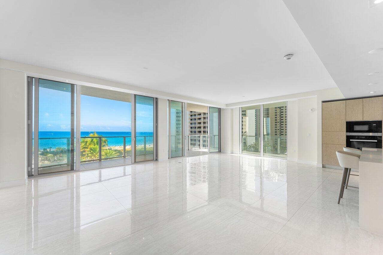 A bright, open-concept living area features white tile floors, floor-to-ceiling windows, and ocean views — 3100 N Ocean Drive # P705, Riviera Beach FL 33404, RIVIERA BEACH, FL