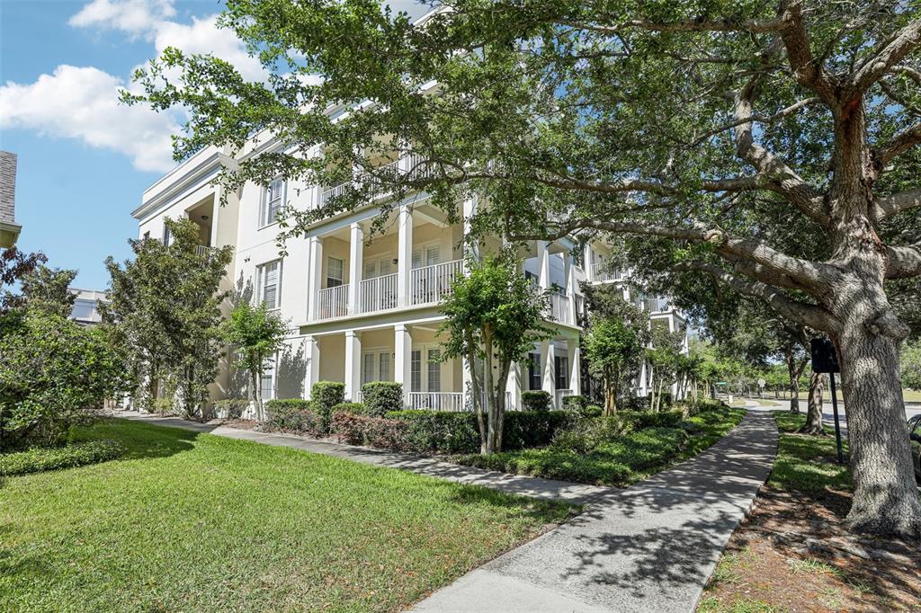 A three-story white apartment building with balconies and a sidewalk surrounded by trees — 2315 UPPER PARK ROAD UNIT 302, ORLANDO, FL
