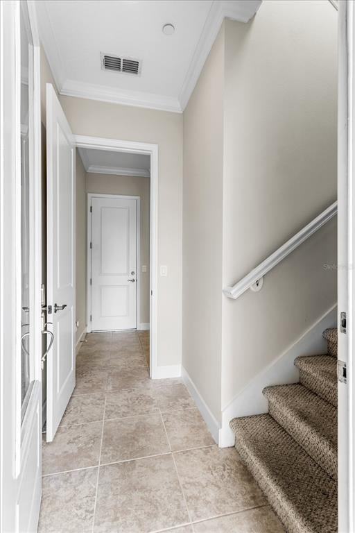 A tiled entryway features a staircase with carpeted steps and a white door — 13433 GRANGER AVENUE, ORLANDO, FL