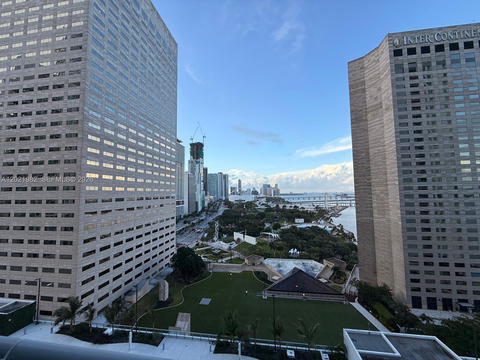 An elevated view shows a park between two tall office buildings overlooking a waterfront — 325 S Biscayne Blvd # 2024, Miami FL 33131, MIAMI, FL