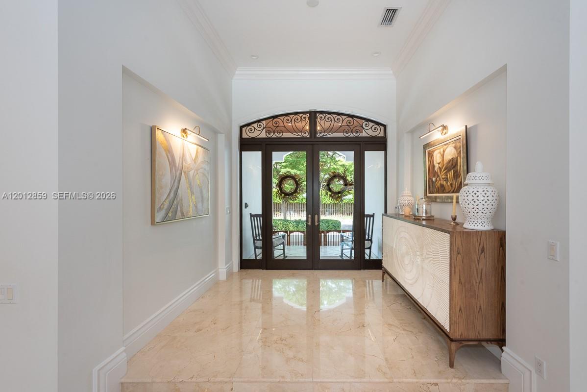 A bright entryway features marble floors, a wooden console table, and double glass front doors — 12311 SW 94th Ave, Miami FL 33176, MIAMI, FL