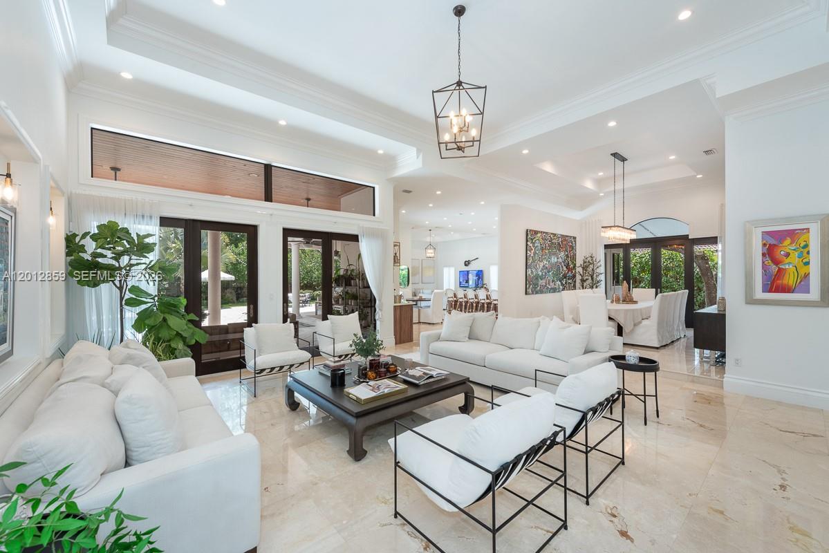 A bright, open-concept living room features white sofas, a dark coffee table, and marble flooring — 12311 SW 94th Ave, Miami FL 33176, MIAMI, FL
