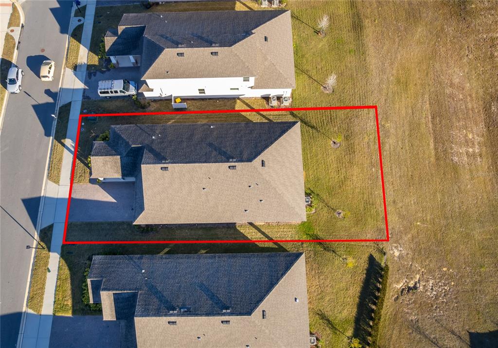 An aerial view shows a single-family house with a large backyard outlined in red — 2060 KEYSTONE PASS BOULEVARD, MINNEOLA, FL