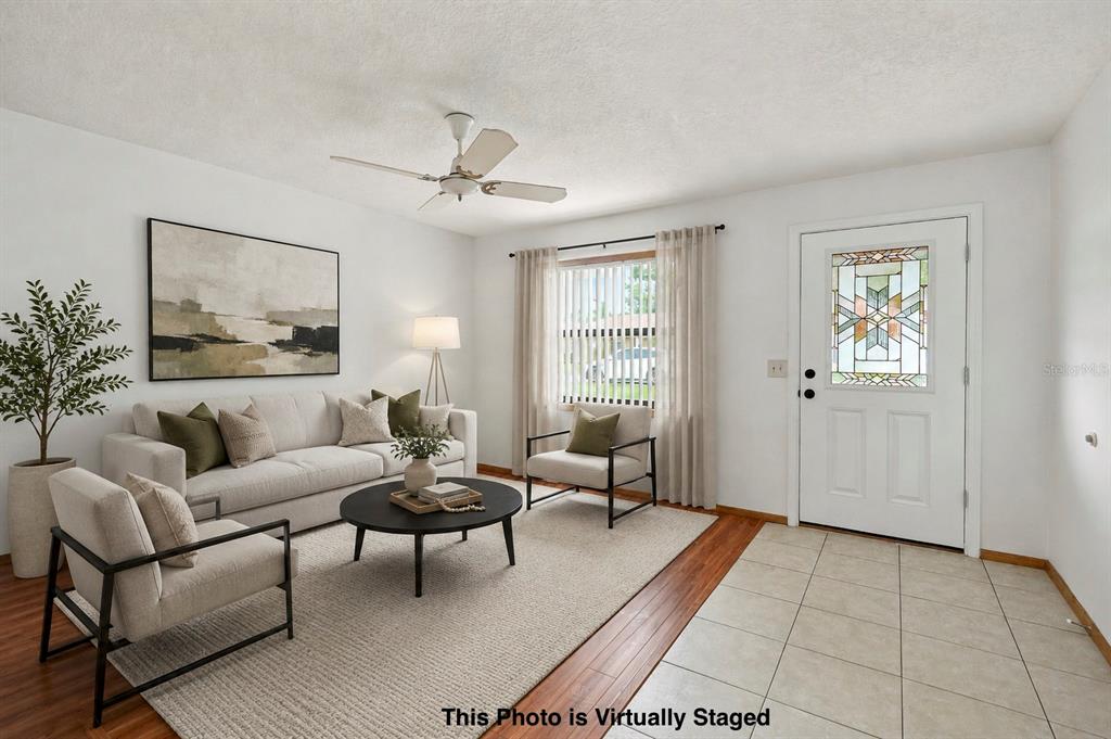 A living room with white walls, wood floors, a ceiling fan, and a front door — 2151 MEREDITH DRIVE, SPRING HILL, FL