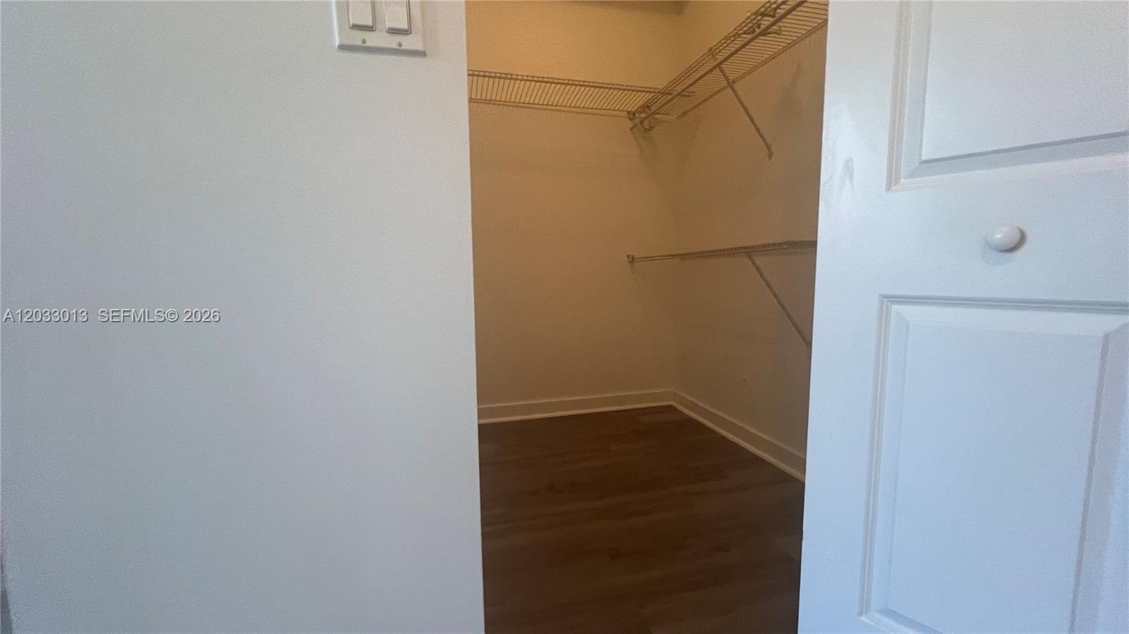 A walk-in closet features white walls, wood-look flooring, and wire shelving — 601 NE 23rd St # 1004, Miami FL 33137, MIAMI, FL