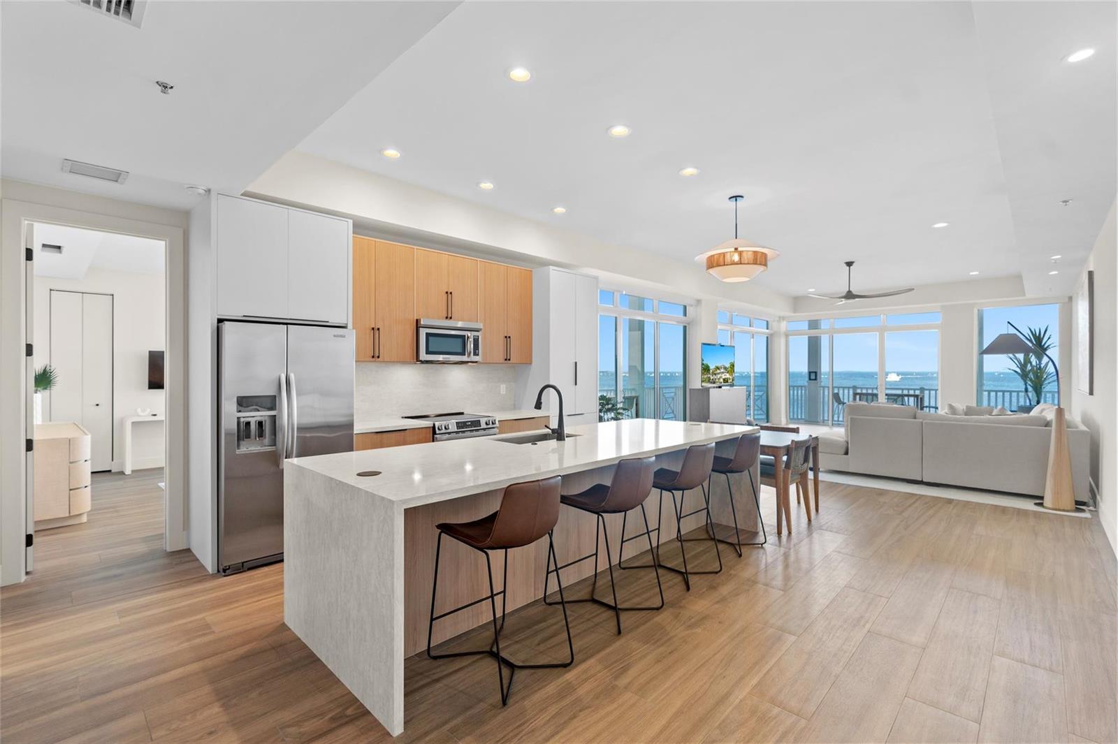 A modern kitchen with a large island and bar seating overlooks a bright living area — 104000 Overseas Highway, Key Largo FL 33037, KEY LARGO, FL