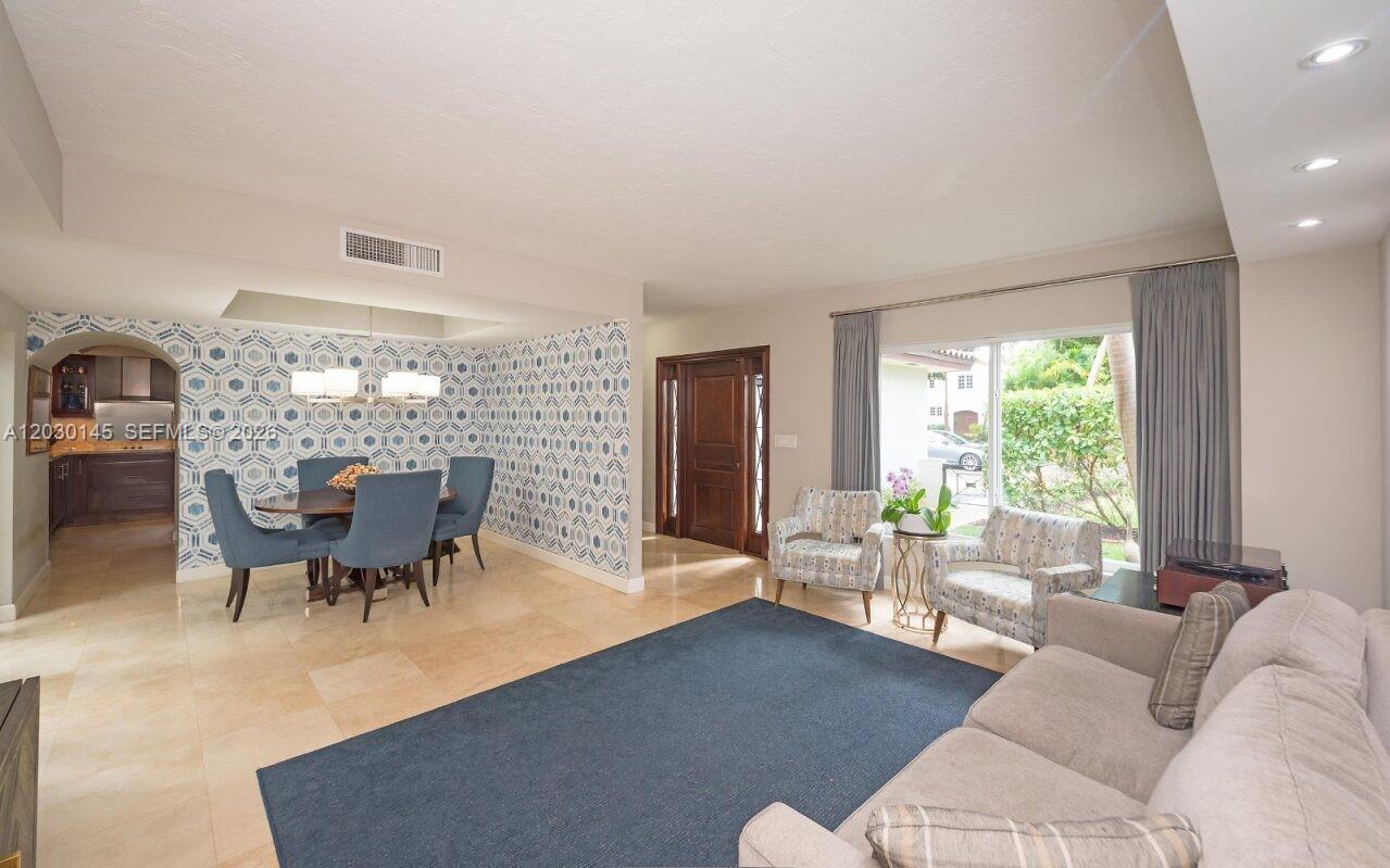 A living and dining area features tile flooring, patterned wallpaper, and a large window — 423 Alhambra Cir, Coral Gables FL 33134, CORAL GABLES, FL