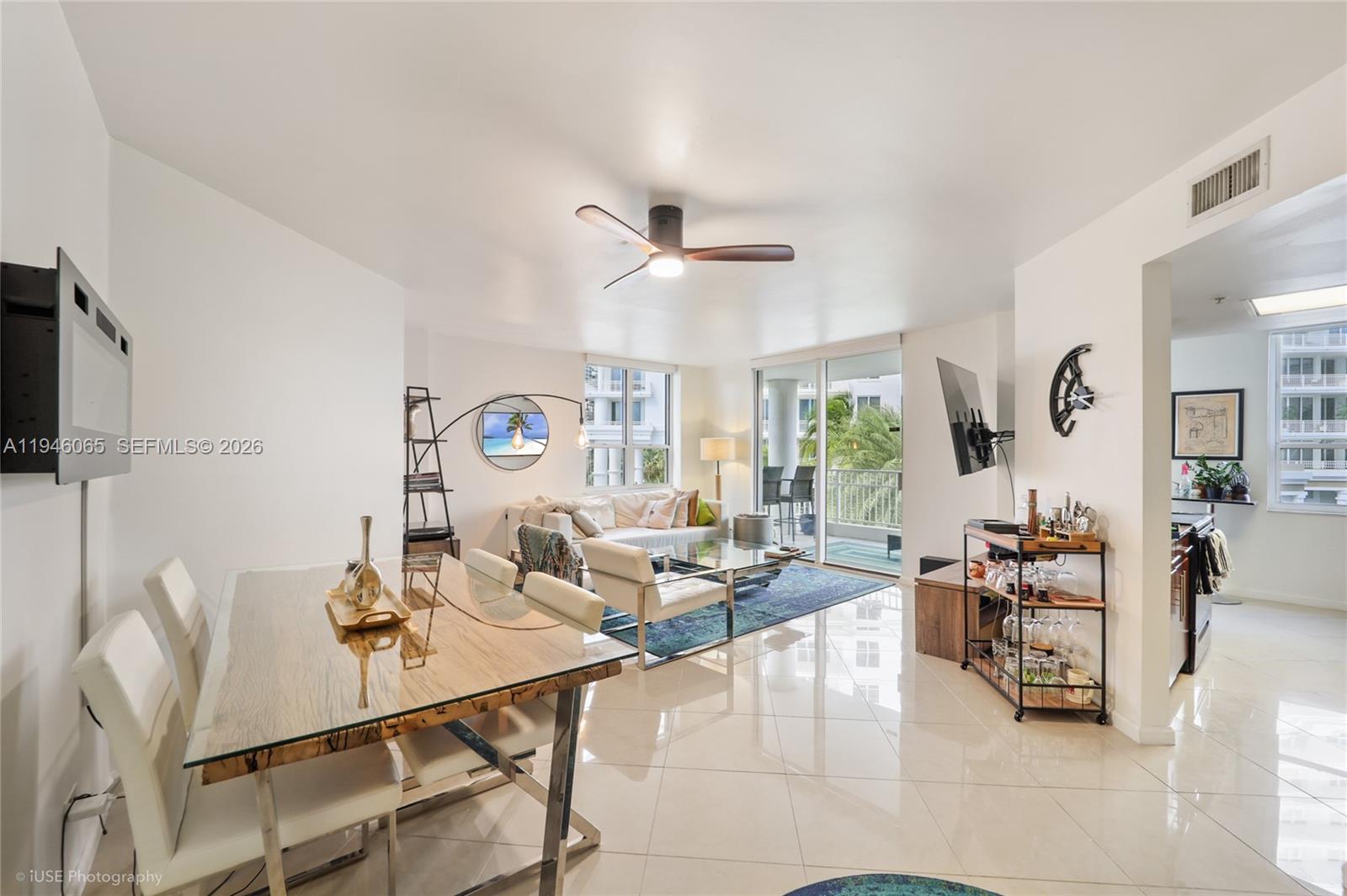 A bright, open-concept living and dining area features white tile floors and a glass-topped table — 701 Brickell Key Blvd # 404, Miami FL 33131, MIAMI, FL