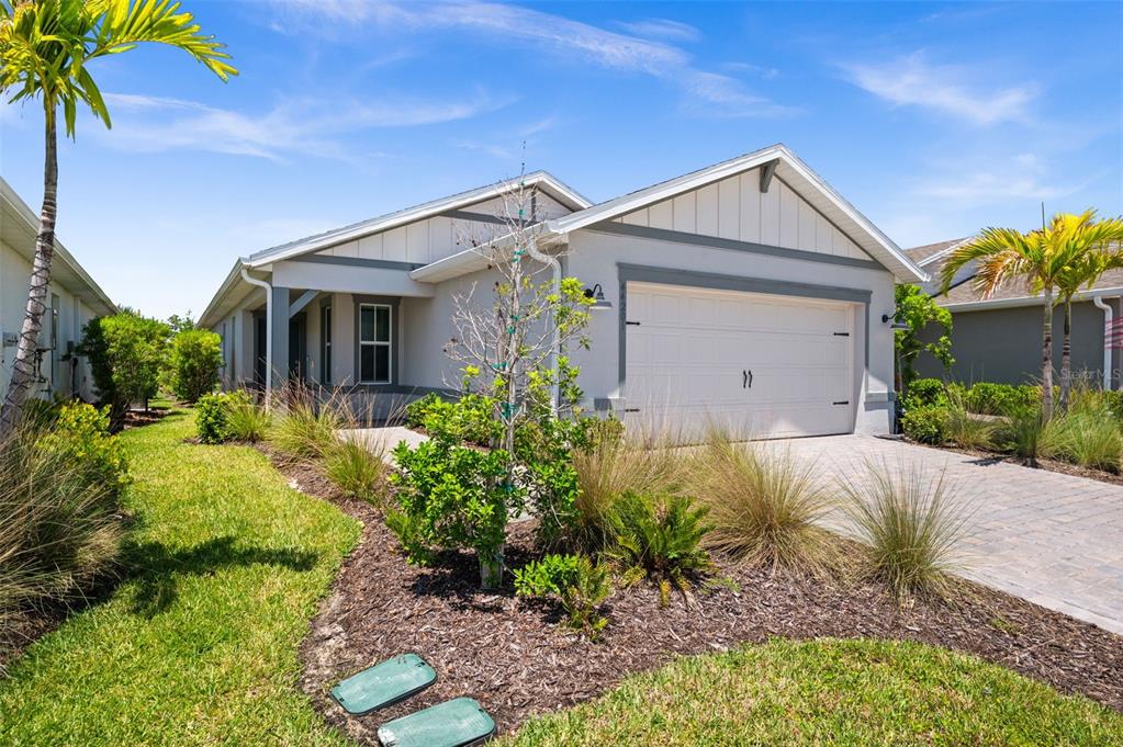 A single-story house with a white garage, gray trim, and a landscaped front yard — 44201 KELLY DRIVE, PUNTA GORDA, FL