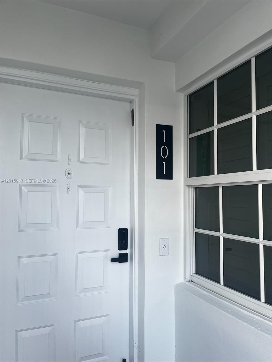 A white front door with a digital lock and a vertical unit number sign — 300 John F Kennedy Dr # 101, Atlantis FL 33462, ATLANTIS, FL