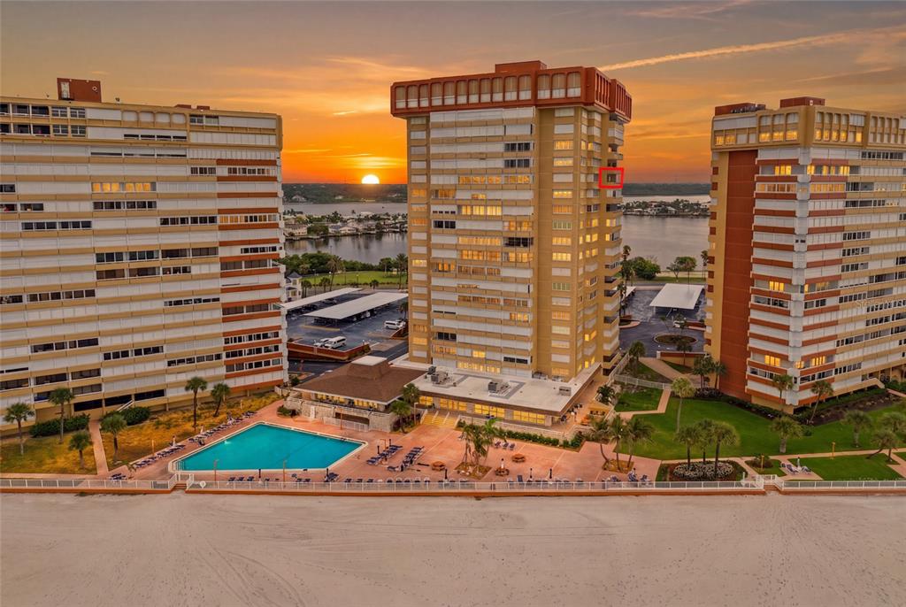 An aerial view shows three tall apartment buildings situated on a sandy beach with pools — 17920 GULF BOULEVARD UNIT 1502, ST PETERSBURG, FL