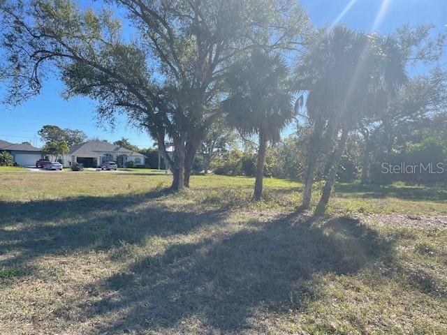 A vacant, grassy lot features several large trees and palm trees under a sunny sky — 48 & 50 TEE VIEW TERRACE, ROTONDA WEST, FL