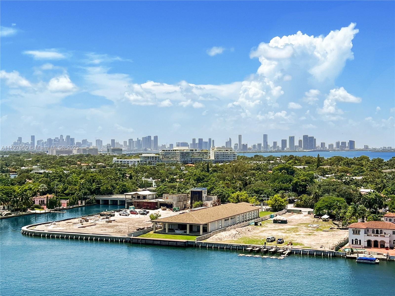 An aerial view shows a waterfront construction site with a large building and city skyline — 5151 Collins Ave # 1523, Miami Beach FL 33140, MIAMI BEACH, FL
