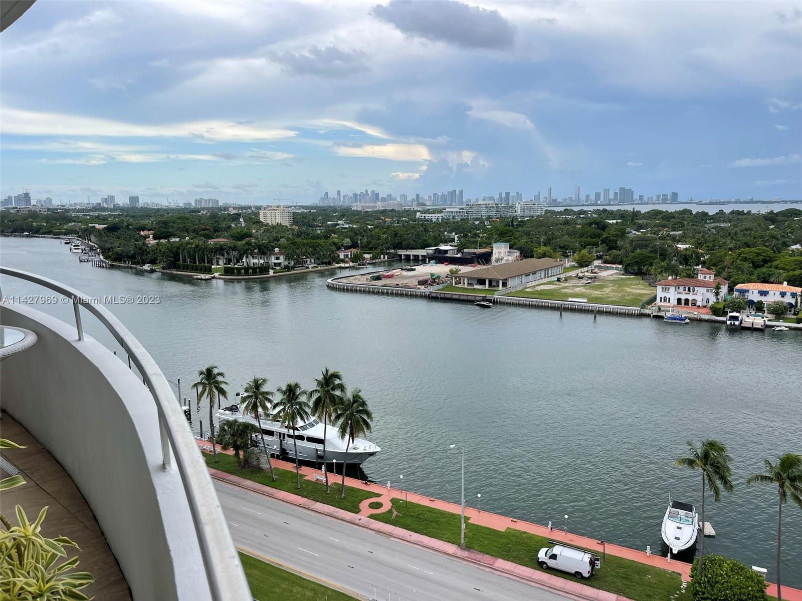 An elevated view shows a waterway, a road with a parked van, and a distant city skyline — 5151 Collins Ave # 1523, Miami Beach FL 33140, MIAMI BEACH, FL