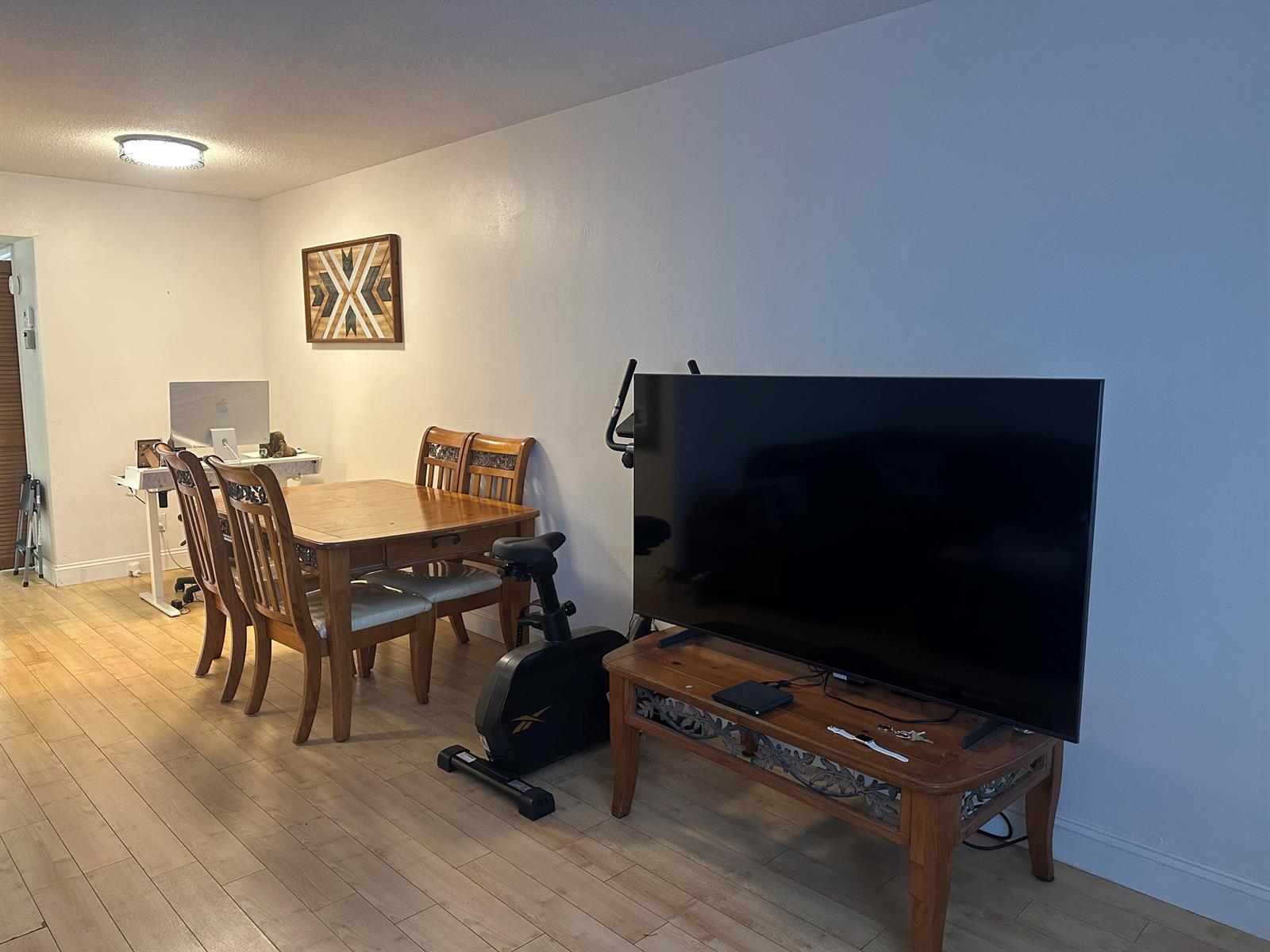 A dining area and living space feature a wooden table, chairs, and a television stand — 2565 S Ocean Boulevard # C, Palm Beach FL 33480, PALM BEACH, FL