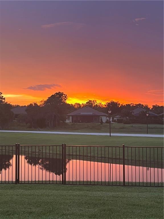 A view of a sunset over a pond with a black fence and houses — 4103 Keeson Circle, Vero Beach FL 32967, VERO BEACH, FL