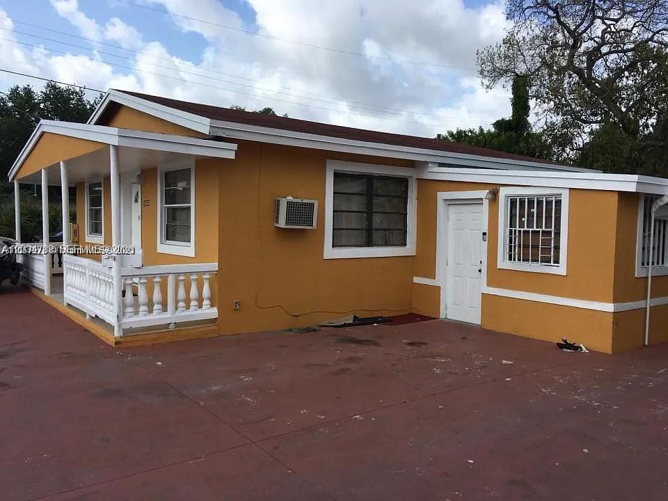 A single-story yellow house with a white porch and a red concrete driveway — 10040 NW 8th Ave, Miami FL 33150, MIAMI, FL