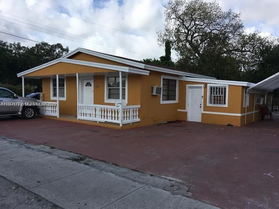 A single-story yellow house with a front porch and a paved driveway — 10040 NW 8th Ave, Miami FL 33150, MIAMI, FL