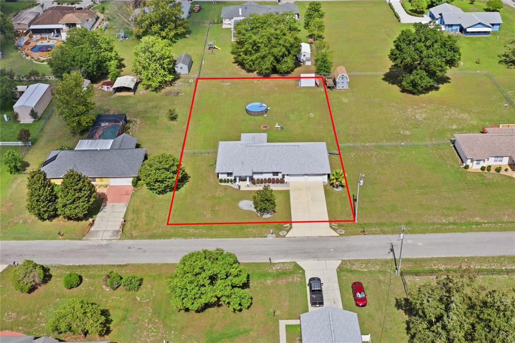 An aerial view shows a single-story house with a pool and fenced yard — 14460 SE 98TH COURT, SUMMERFIELD, FL