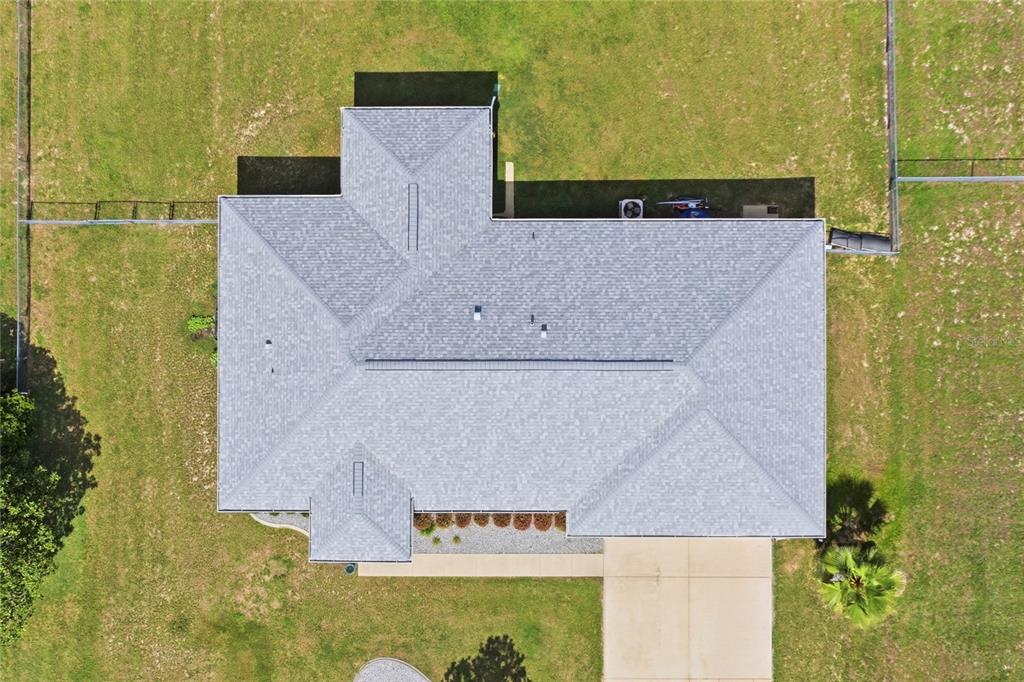 An aerial view shows the grey shingled roof of a house surrounded by a grassy yard — 14460 SE 98TH COURT, SUMMERFIELD, FL