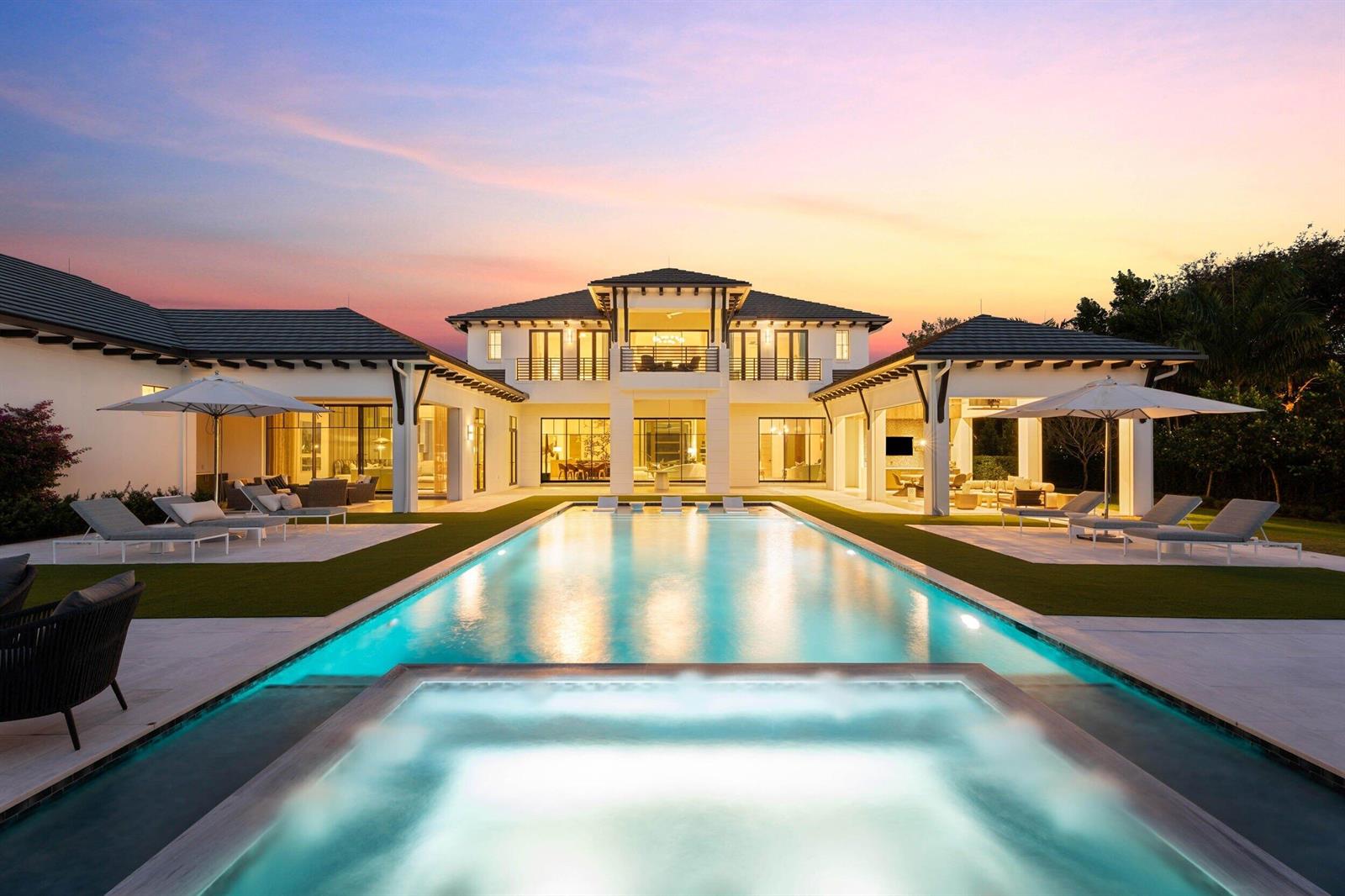 A two-story luxury home with a swimming pool, hot tub, and patio at sunset — 210 Bears Club Drive, Jupiter FL 33477, JUPITER, FL