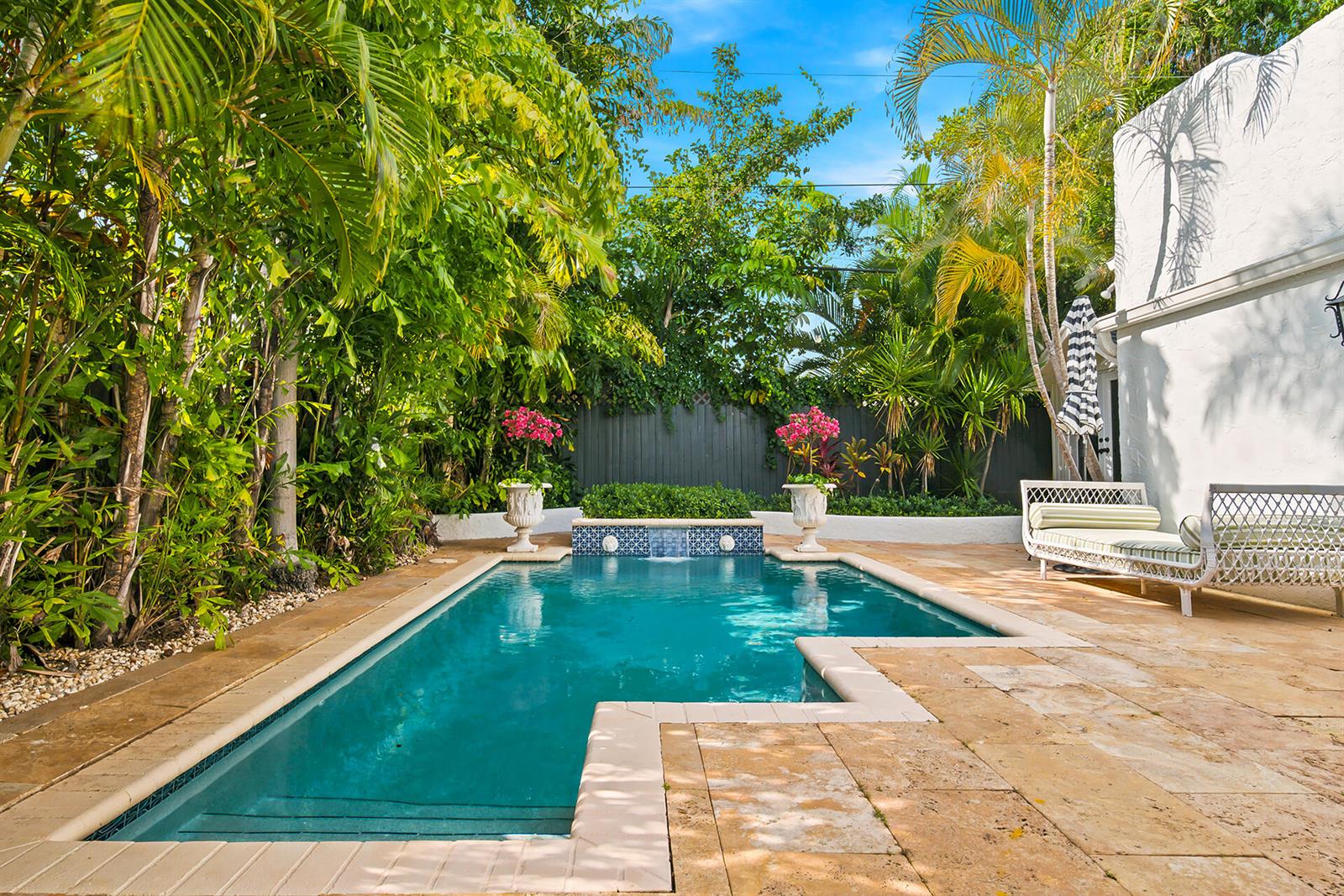 A rectangular swimming pool with a stone deck and lush tropical landscaping in a backyard — 235 Nottingham Boulevard, West Palm Beach FL 33405, WEST PALM BEACH, FL