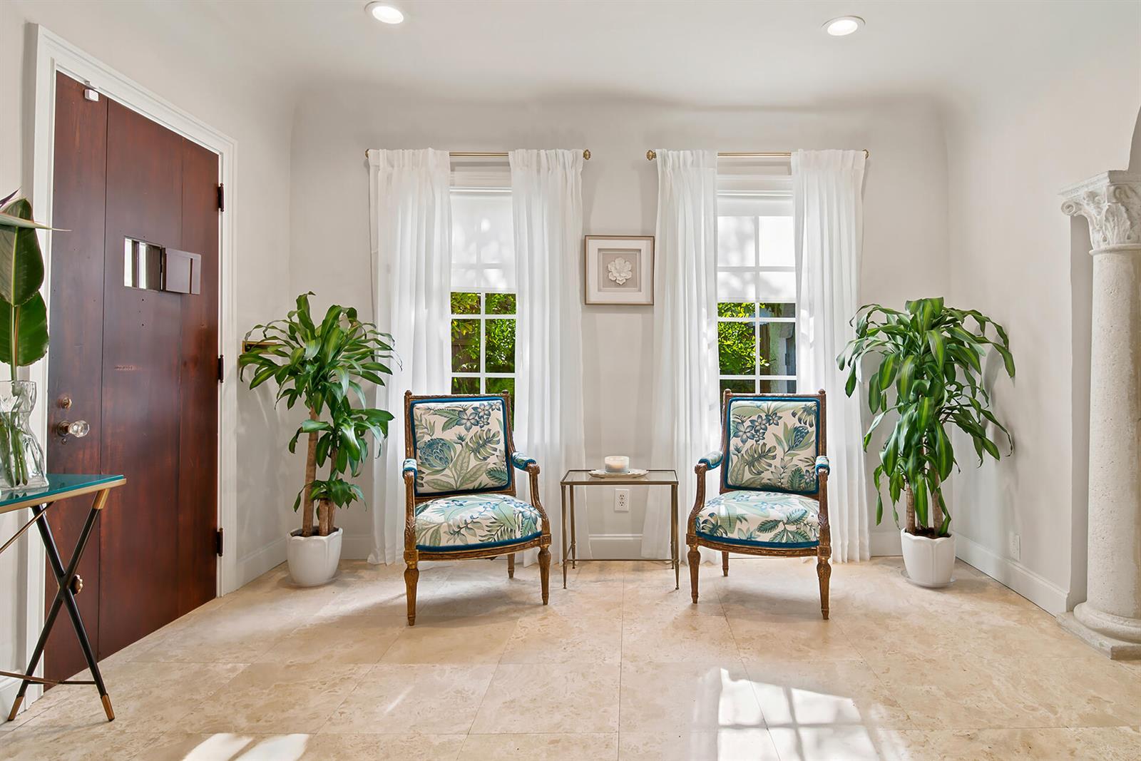 A bright room features two patterned armchairs, potted plants, and white curtains by windows — 235 Nottingham Boulevard, West Palm Beach FL 33405, WEST PALM BEACH, FL
