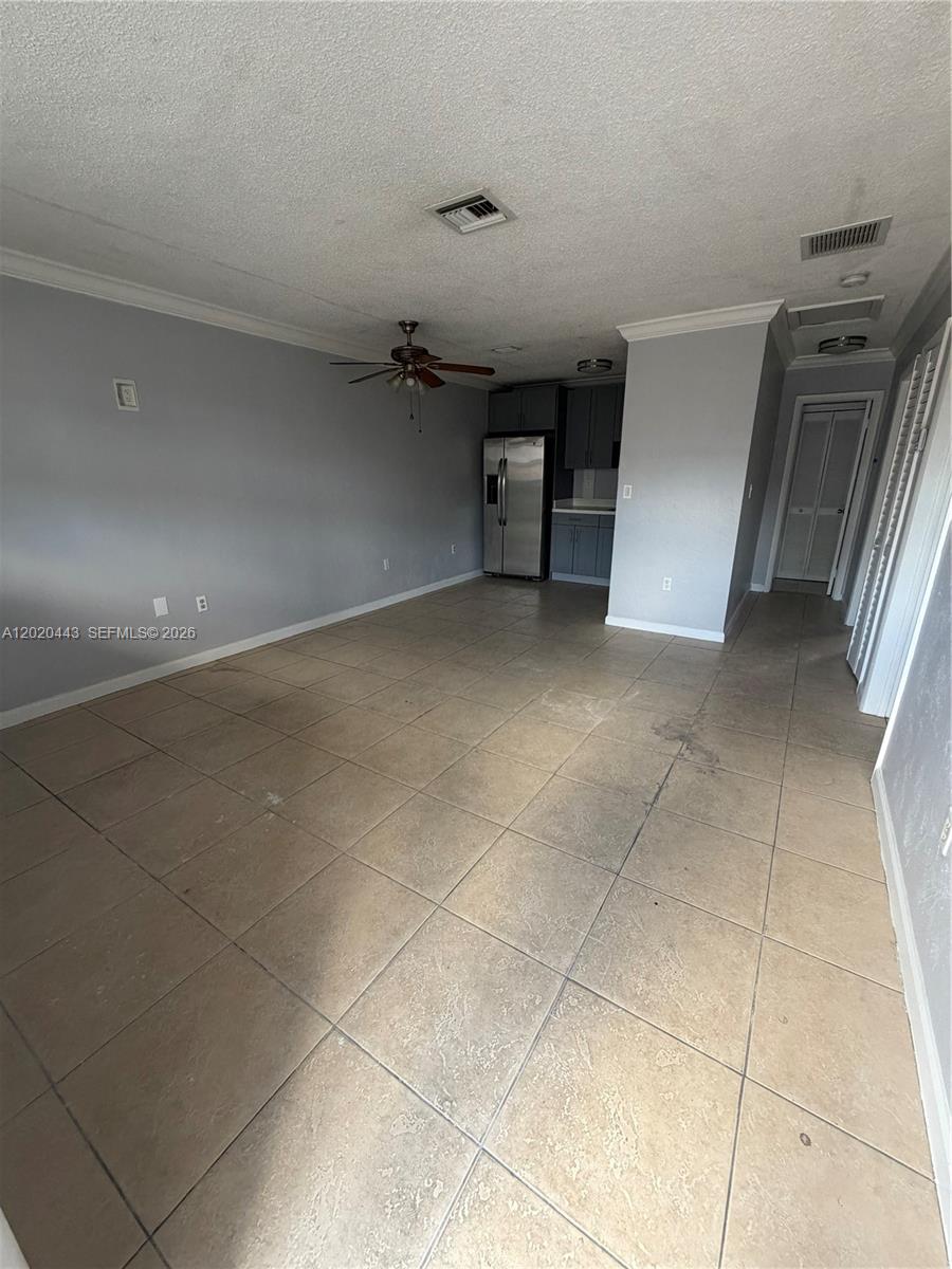 An open-concept living area features light gray walls, large beige floor tiles, and a kitchen — 2924 NW 132nd Ter # 2, Opa-Locka FL 33054, OPA-LOCKA, FL