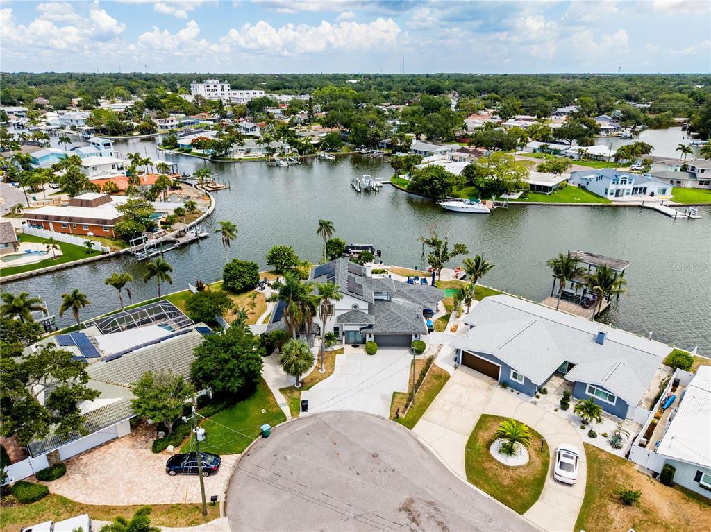 An aerial view shows waterfront homes with pools and docks along a canal — 4124 HARBOR CIRCLE S, LARGO, FL