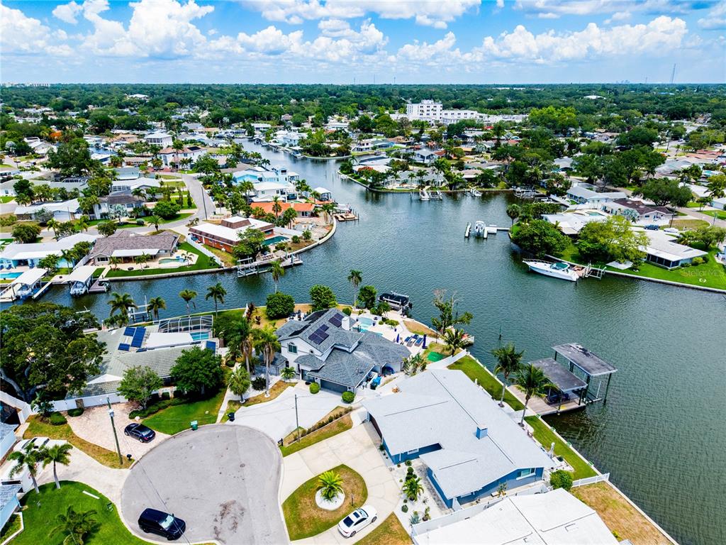 An aerial view shows waterfront houses with docks and swimming pools along a canal — 4124 HARBOR CIRCLE S, LARGO, FL