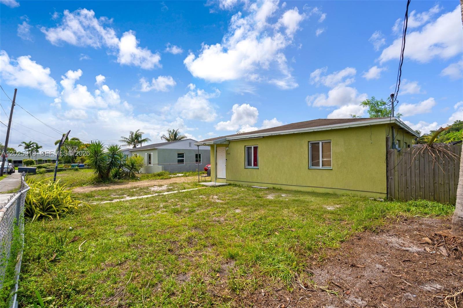 A lime-green single-story house stands on a grassy lot under a blue sky — 2365 NW 155th St, Miami Gardens FL 33054, MIAMI GARDENS, FL