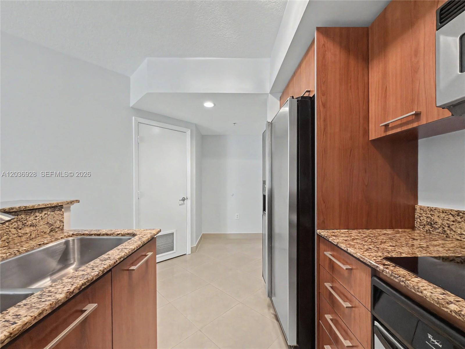 A kitchen featuring wood cabinets, granite countertops, stainless steel appliances, and tile flooring — 9055 SW 73rd Ct # 1004, Pinecrest FL 33156, PINECREST, FL