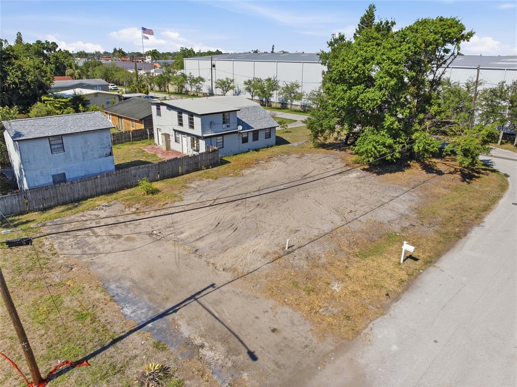 An aerial view shows a vacant, sandy residential lot next to a two-story house — 6500 49TH WAY N, PINELLAS PARK, FL