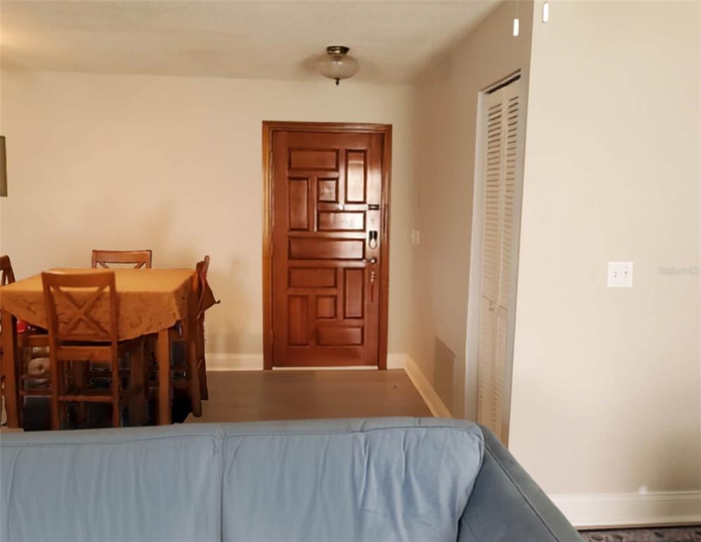 A dining area with a wooden table and chairs sits beside a decorative front door — 1217 MARDRAKE ROAD, DAYTONA BEACH, FL