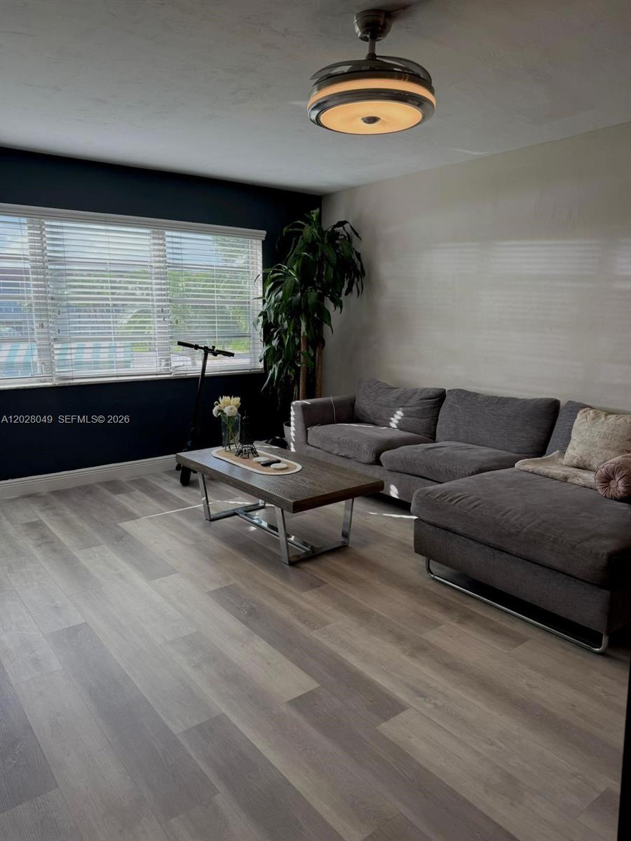 A living room features a grey sectional sofa, a wooden coffee table, and a ceiling fan — 1530 NE 191st St # 241, Miami FL 33179, MIAMI, FL
