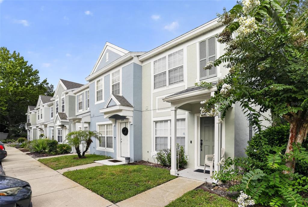 A row of two-story townhomes with light-colored siding, front porches, and small front lawns — 866 VINELAND PLACE, LAKE MARY, FL