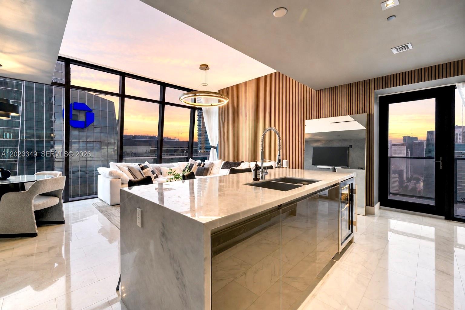 A modern kitchen island with marble countertops sits in a living area with floor-to-ceiling windows — 1451 Brickell Ave # 4304, Miami FL 33131, MIAMI, FL