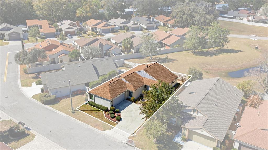 An aerial view shows a single-story house with a brown roof and a concrete driveway — 4427 NE 5TH STREET, OCALA, FL