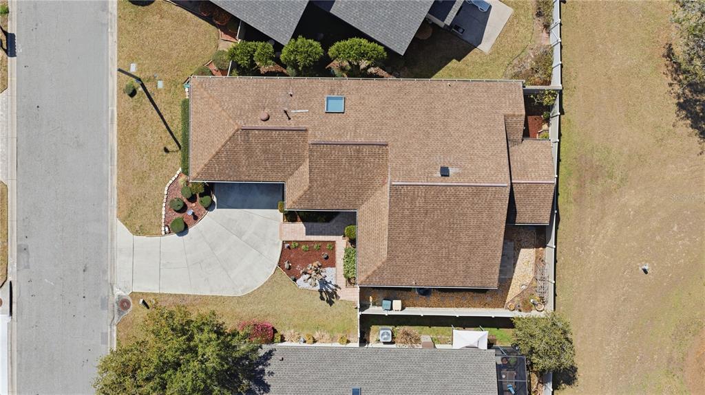 An aerial view shows a single-story house with a brown shingled roof and driveway — 4427 NE 5TH STREET, OCALA, FL