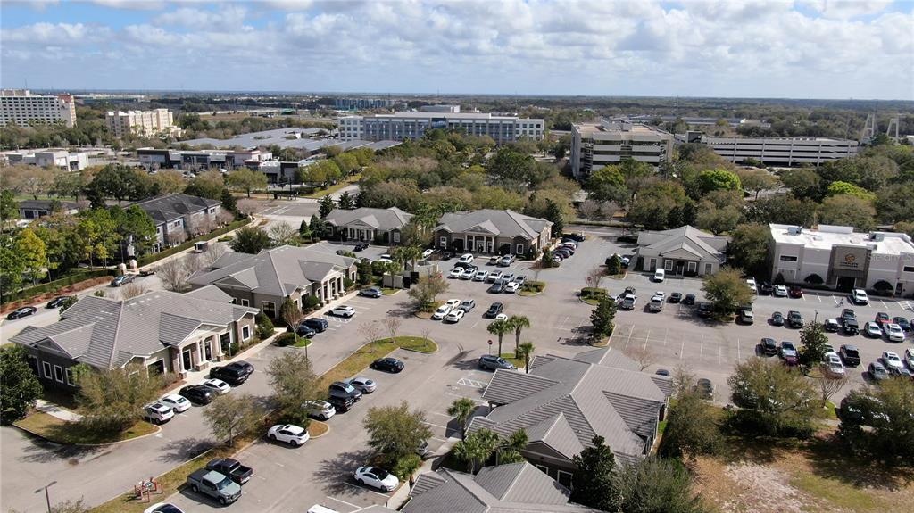 An aerial view shows several commercial office buildings surrounded by parking lots and trees — 938 INTERNATIONAL PARKWAY UNIT 1510, LAKE MARY, FL