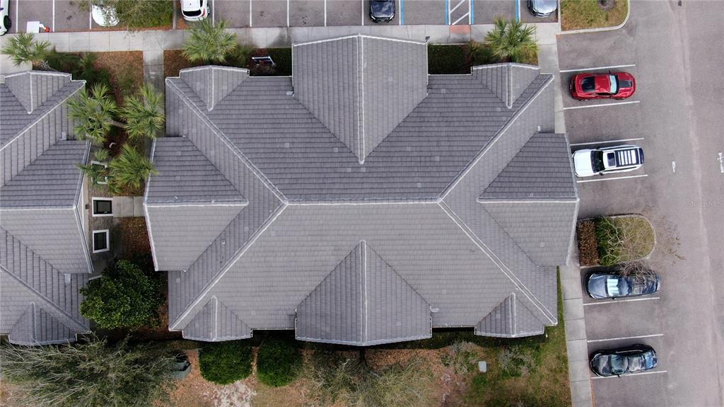 An aerial view shows the gray tiled roof of a building next to a parking lot — 938 INTERNATIONAL PARKWAY UNIT 1510, LAKE MARY, FL