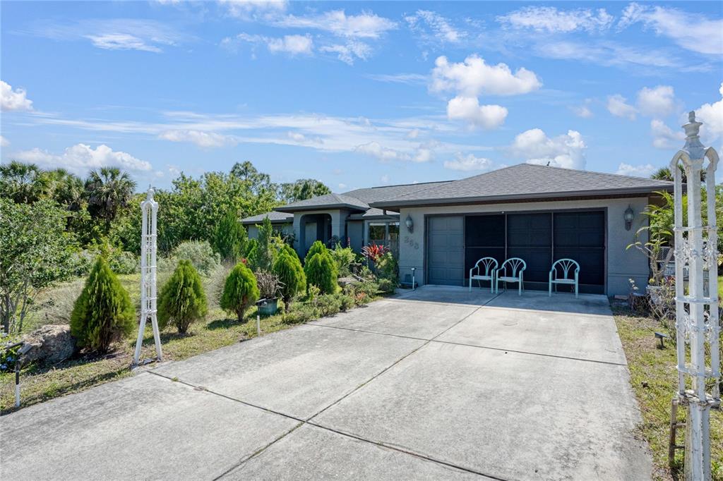 A single-story house with a concrete driveway, a two-car garage, and landscaped front yard — 268 CORY STREET, PORT CHARLOTTE, FL