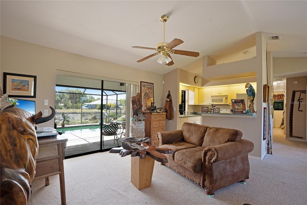 A living room with a brown sofa, a wooden coffee table, and a sliding glass door — 268 CORY STREET, PORT CHARLOTTE, FL