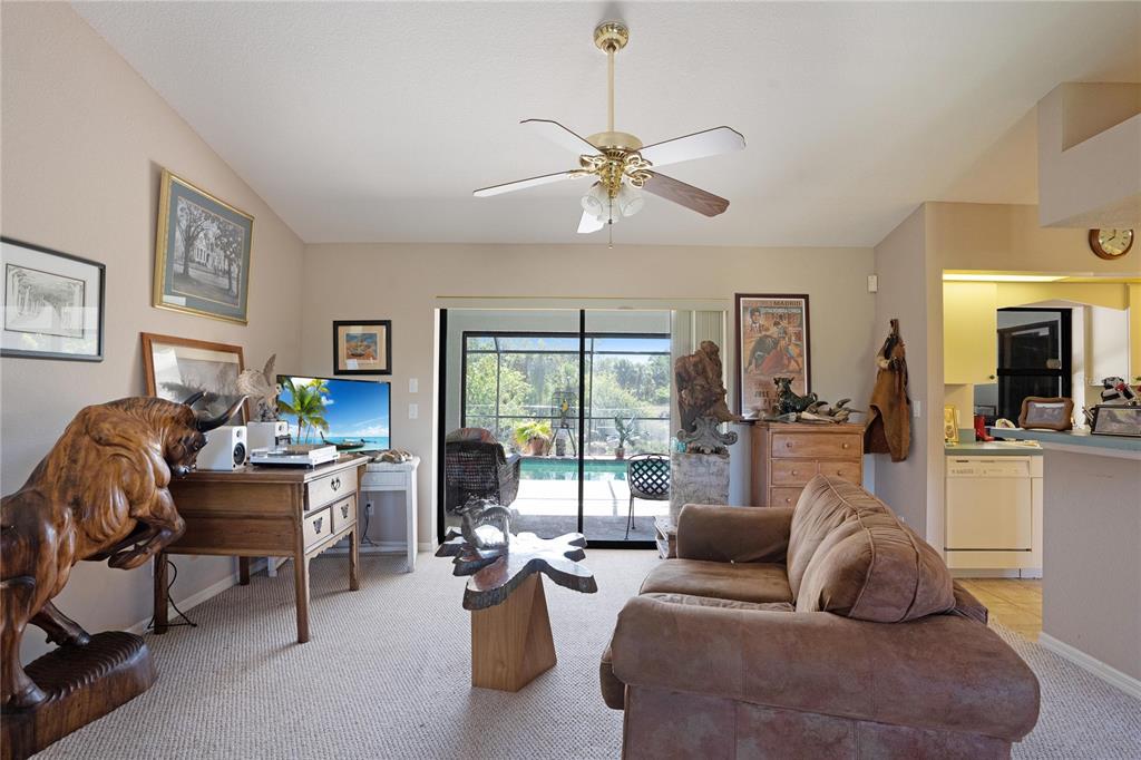 A living room features a wooden bull sculpture, a brown sofa, and a sliding glass door — 268 CORY STREET, PORT CHARLOTTE, FL