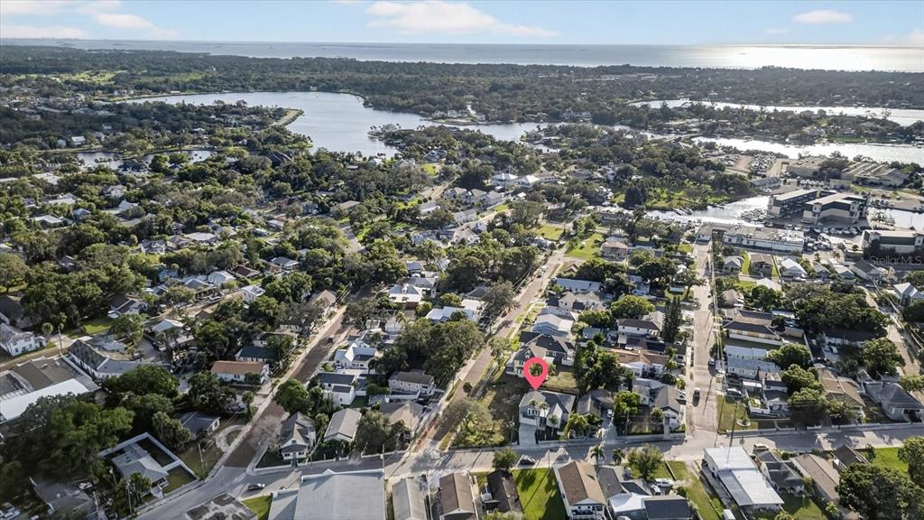 An aerial view shows a residential neighborhood with a highlighted house near a coastal waterway — 207 ATHENS STREET, TARPON SPRINGS, FL