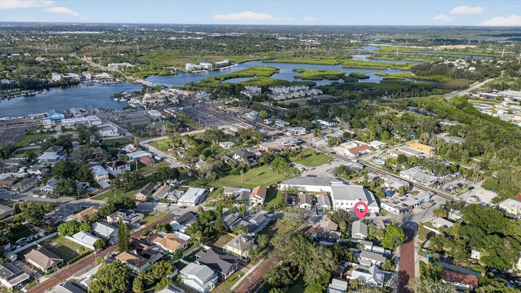 An aerial view shows a residential neighborhood near a coastal waterway with a red location marker — 207 ATHENS STREET, TARPON SPRINGS, FL